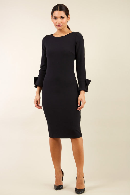 brunette model wearing diva catwalk fitted dress with sleeves called Alma Pencil-skirt dress in colour black with bow detail on sleeves front