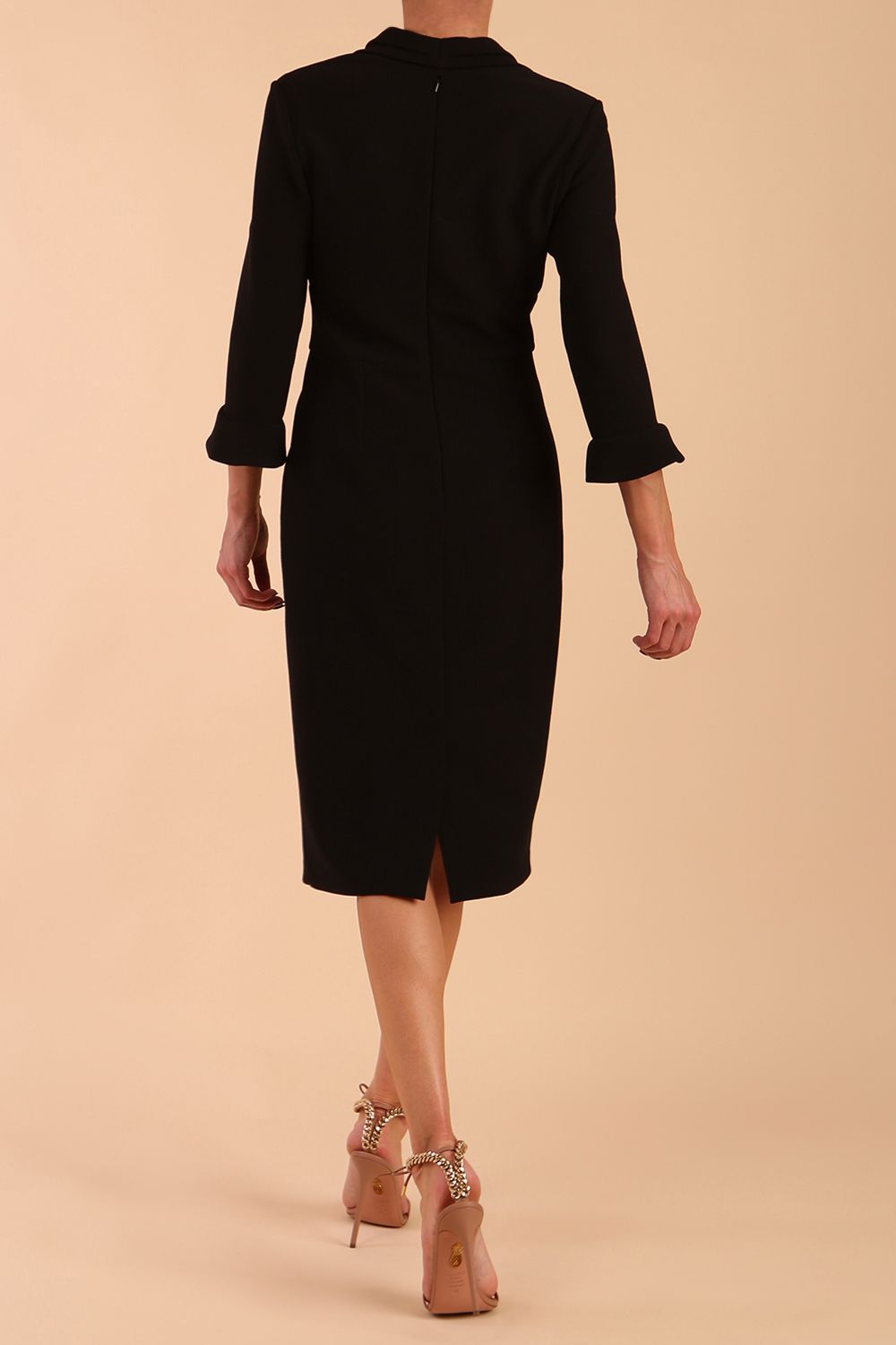 brunette model wearing diva catwalk adriana pencil dress with low v-neck and pleating around shoulders with three quarter sleeve detailed on end and wide waistband in black front