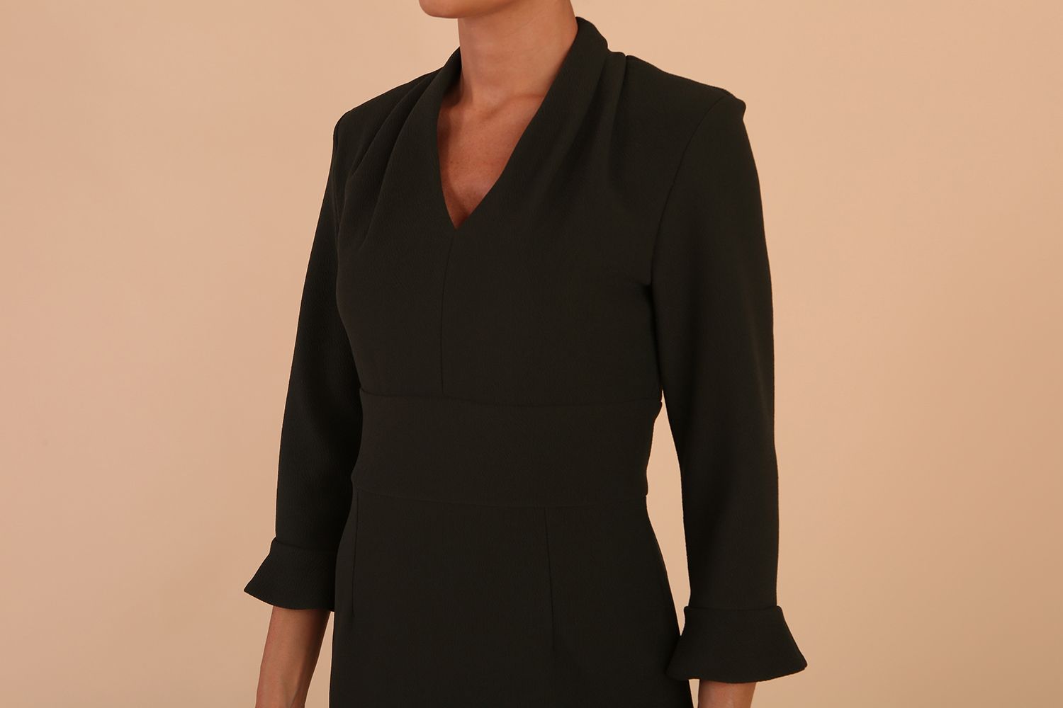 brunette model wearing diva catwalk adriana pencil dress with low v-neck and pleating around shoulders with three quarter sleeve detailed on end and wide waistband in obsidian green front side