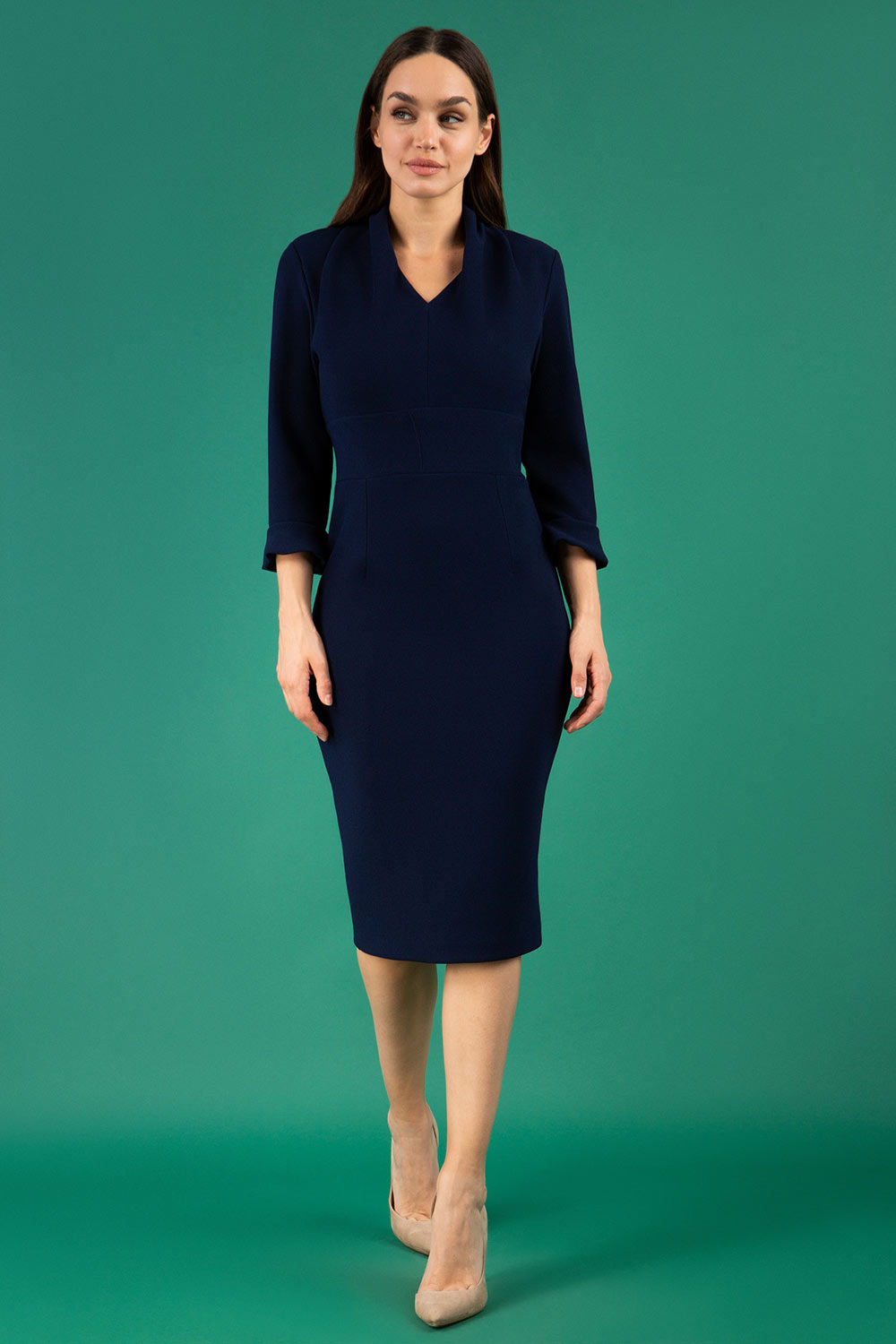 brunette model wearing diva catwalk adriana pencil dress with low v-neck and pleating around shoulders with three quarter sleeve detailed on end and wide waistband in dark navy front