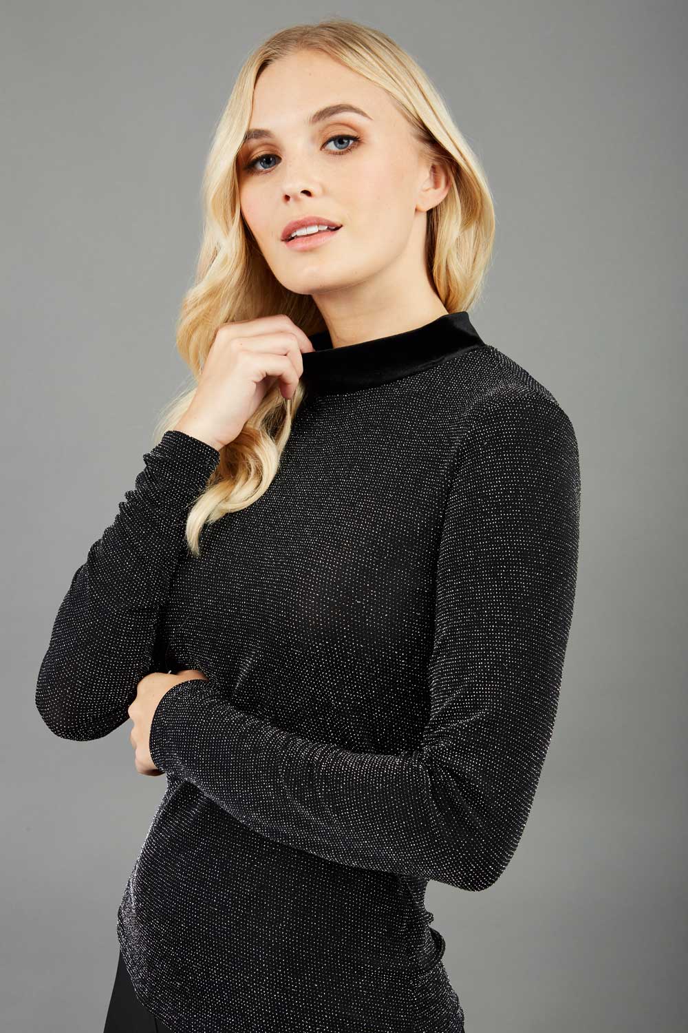 Blonde hair model is wearing a jersey sparkle velvet turtleneck blouse top  front image