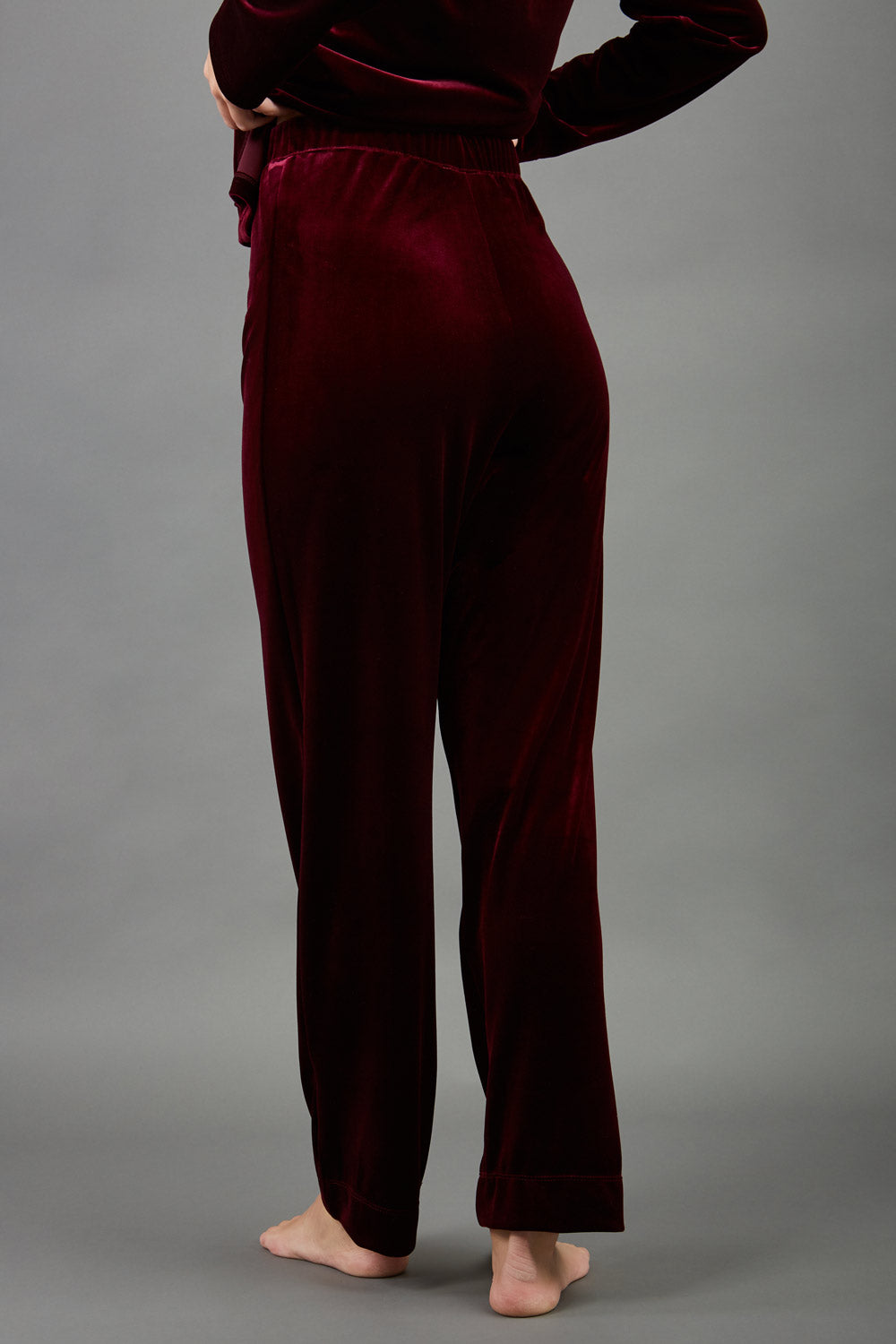 model wearing diva catwalk pelham stretch velvet straight leg trousers in velvet with ribbon in burgundy colour front