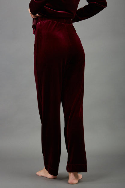 model wearing diva catwalk pelham stretch velvet straight leg trousers in velvet with ribbon in burgundy colour front