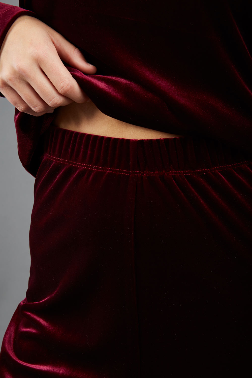 model wearing diva catwalk pelham stretch velvet straight leg trousers in velvet with ribbon in burgundy colour front