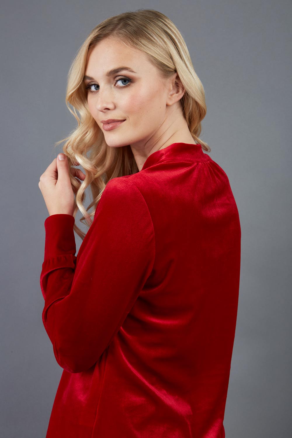 blonde model is wearing diva catwalk allium velvet sleeved high neck top in colour red front