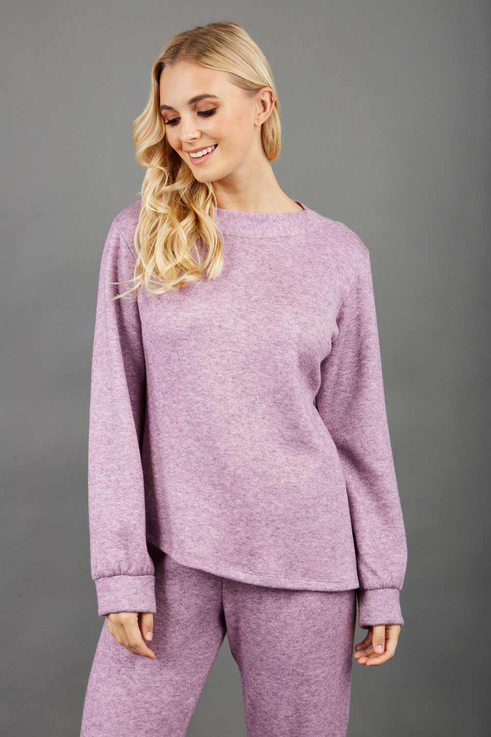 blonde model wearing diva catwalk muscari asymmetric sleeved top with rounded neck in pink front