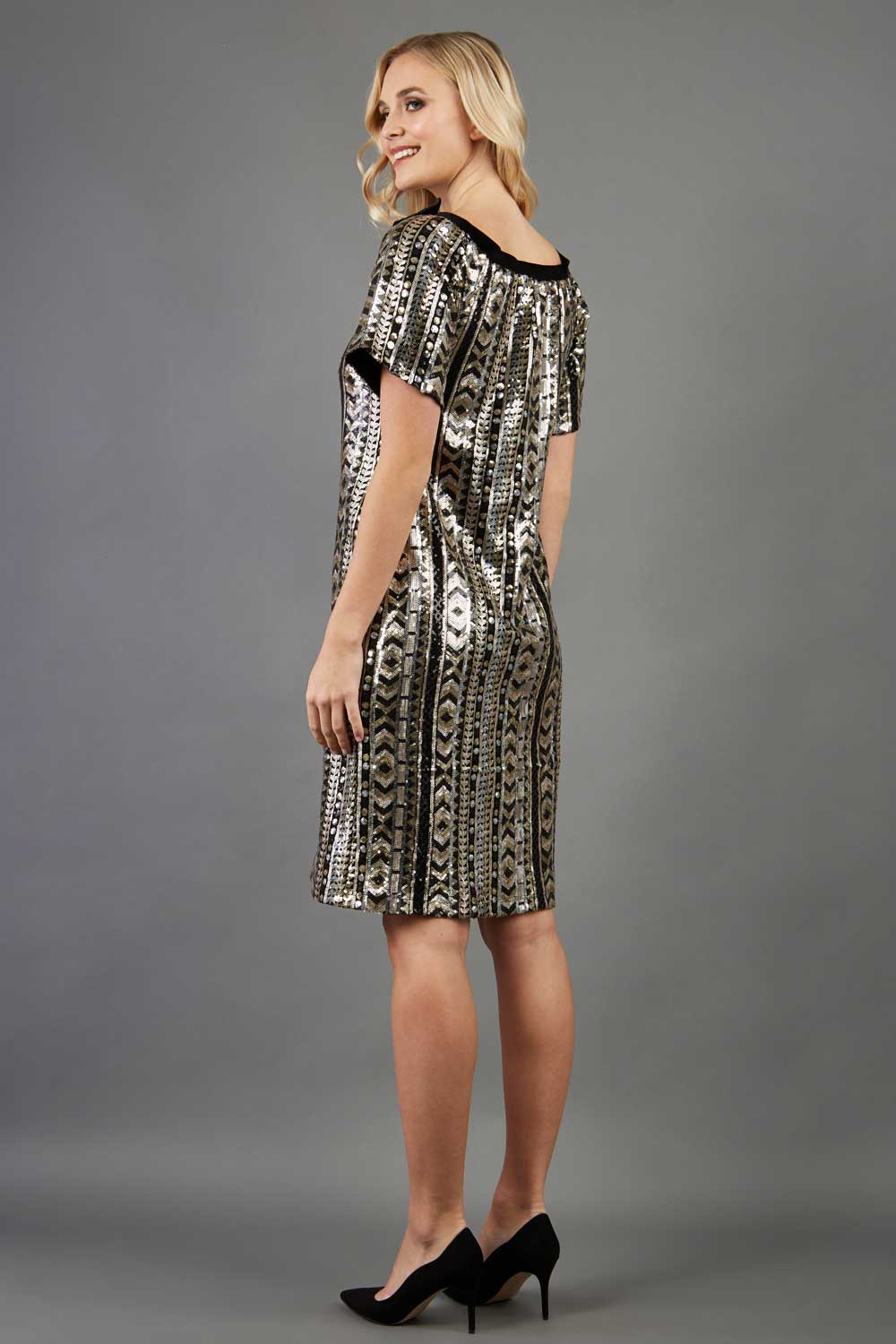blonde model is wearing diva catwalk madonna a-line dress very sparkly Christmas style with short sleeves and velvet bow detail front 