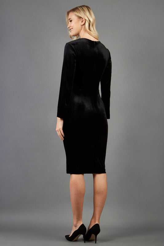 blonde model wearing diva catwalk celine black velvet pencil skirt dress with long sleeves and 3 bow details at the front in black front