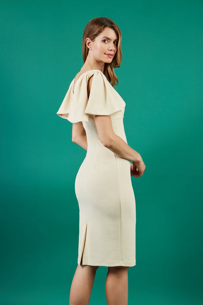 brunette model is wearing diva catwalk hermione pencil dress with tie shoulder details and empire waistline in beige front