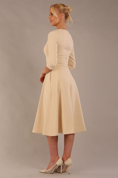 model is wearing diva catwalk casares swing dress with a keyhole neckline three quarter sleeve dress with pocket detail in Sandshell Beige front (Sandshell Beige)