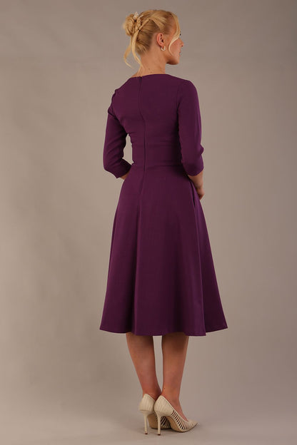 model is wearing diva catwalk casares swing dress with a keyhole neckline three quarter sleeve dress with pocket detail in imperial purple side front (Imperial Purple)