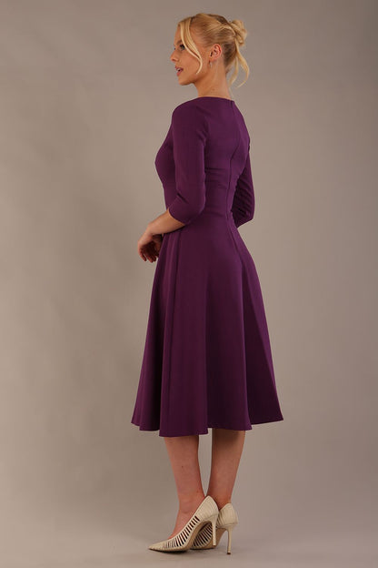 model is wearing diva catwalk casares swing dress with a keyhole neckline three quarter sleeve dress with pocket detail in imperial purple side front (Imperial Purple)