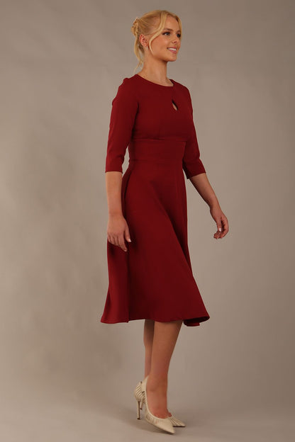 model is wearing diva catwalk casares swing dress with a keyhole neckline three quarter sleeve dress with pocket detail in Wine front side (Wine)