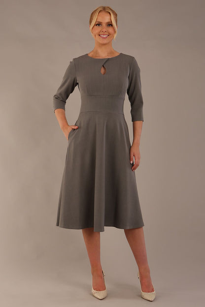 model is wearing diva catwalk casares swing dress with a keyhole neckline three quarter sleeve dress with pocket detail in Castlerock Grey  front (Castlerock Grey)