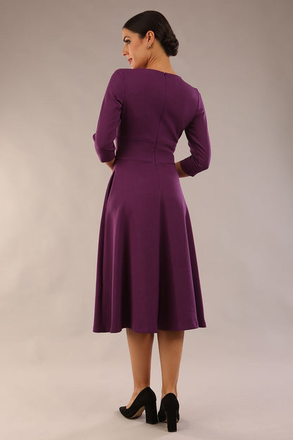 model is wearing diva catwalk casares swing dress with a keyhole neckline three quarter sleeve dress with pocket detail in imperial purple side front (Imperial Purple)