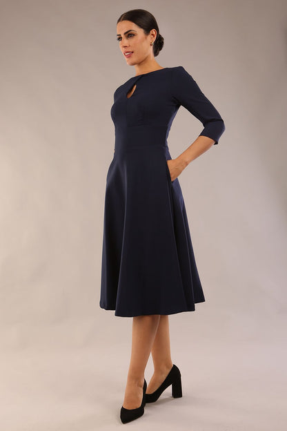  model is wearing diva catwalk casares swing dress with a keyhole neckline three quarter sleeve dress with pocket detail in navy blue front (Navy Blue)
