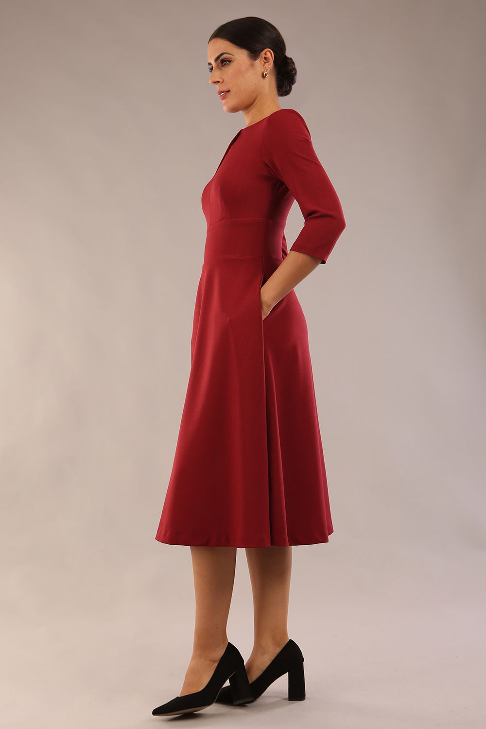 Brunette model is wearing diva catwalk casares swing dress with a keyhole neckline three quarter sleeve dress with pocket detail in Wine front side (Wine)