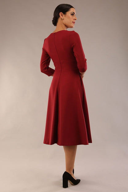 Brunette model is wearing diva catwalk casares swing dress with a keyhole neckline three quarter sleeve dress with pocket detail in Wine front side (Wine)