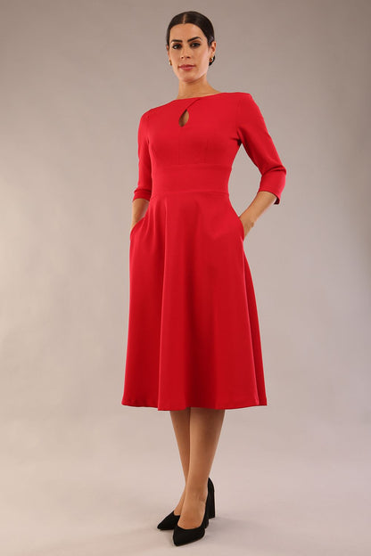 Brunette model is wearing diva catwalk casares swing dress with a keyhole neckline three quarter sleeve dress with pocket detail in red front (Scarlet Red)