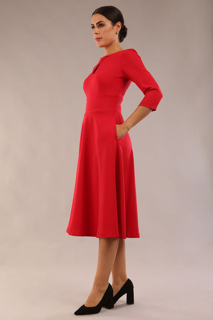 Brunette model is wearing diva catwalk casares swing dress with a keyhole neckline three quarter sleeve dress with pocket detail in red front (Scarlet Red)