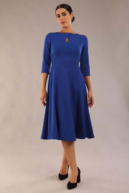 Brunette model is wearing diva catwalk casares swing dress with a keyhole neckline three quarter sleeve dress with pocket detail in cobalt blue front (Cobalt Blue)