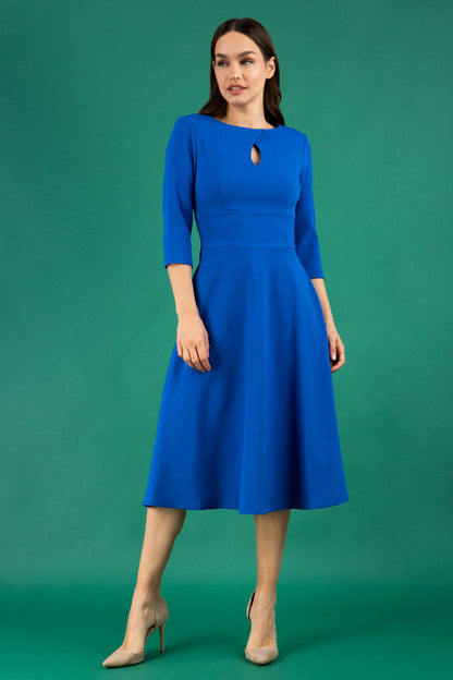 Brunette model is wearing diva catwalk casares swing dress with a keyhole neckline three quarter sleeve dress with pocket detail in cobalt blue front (Cobalt Blue)