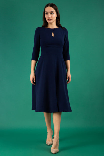  model is wearing diva catwalk casares swing dress with a keyhole neckline three quarter sleeve dress with pocket detail in navy blue front (Navy Blue)