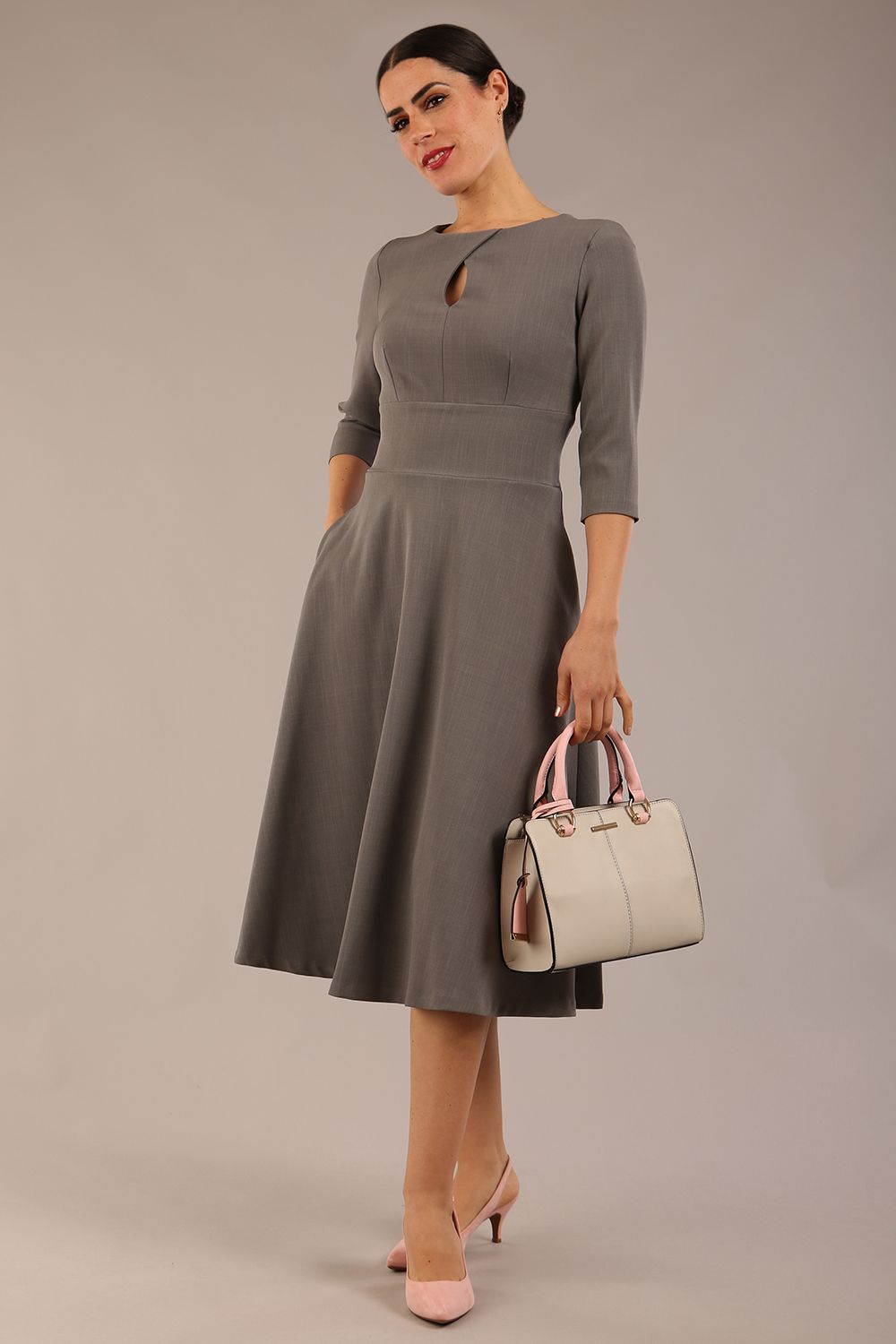 Brunette model is wearing diva catwalk casares swing dress with a keyhole neckline three quarter sleeve dress with pocket detail in Castlerock Grey  front (Castlerock Grey)