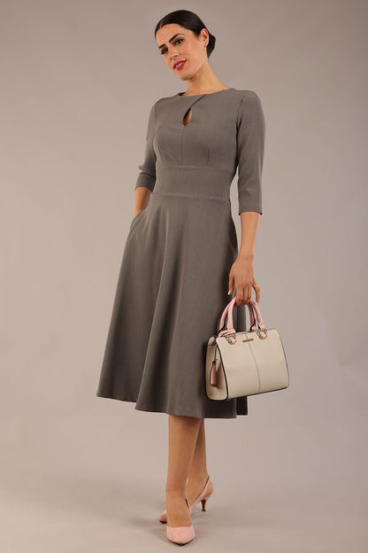 Brunette model is wearing diva catwalk casares swing dress with a keyhole neckline three quarter sleeve dress with pocket detail in Castlerock Grey  front (Castlerock Grey)