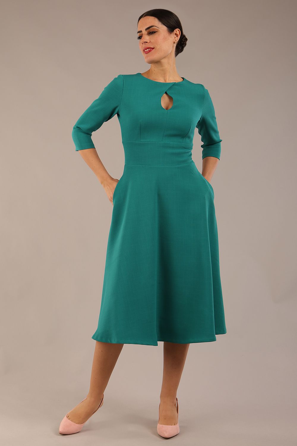 Brunette model is wearing diva catwalk casares swing dress with a keyhole neckline three quarter sleeve dress with pocket detail in Parasailing green front (Parasailing Green)