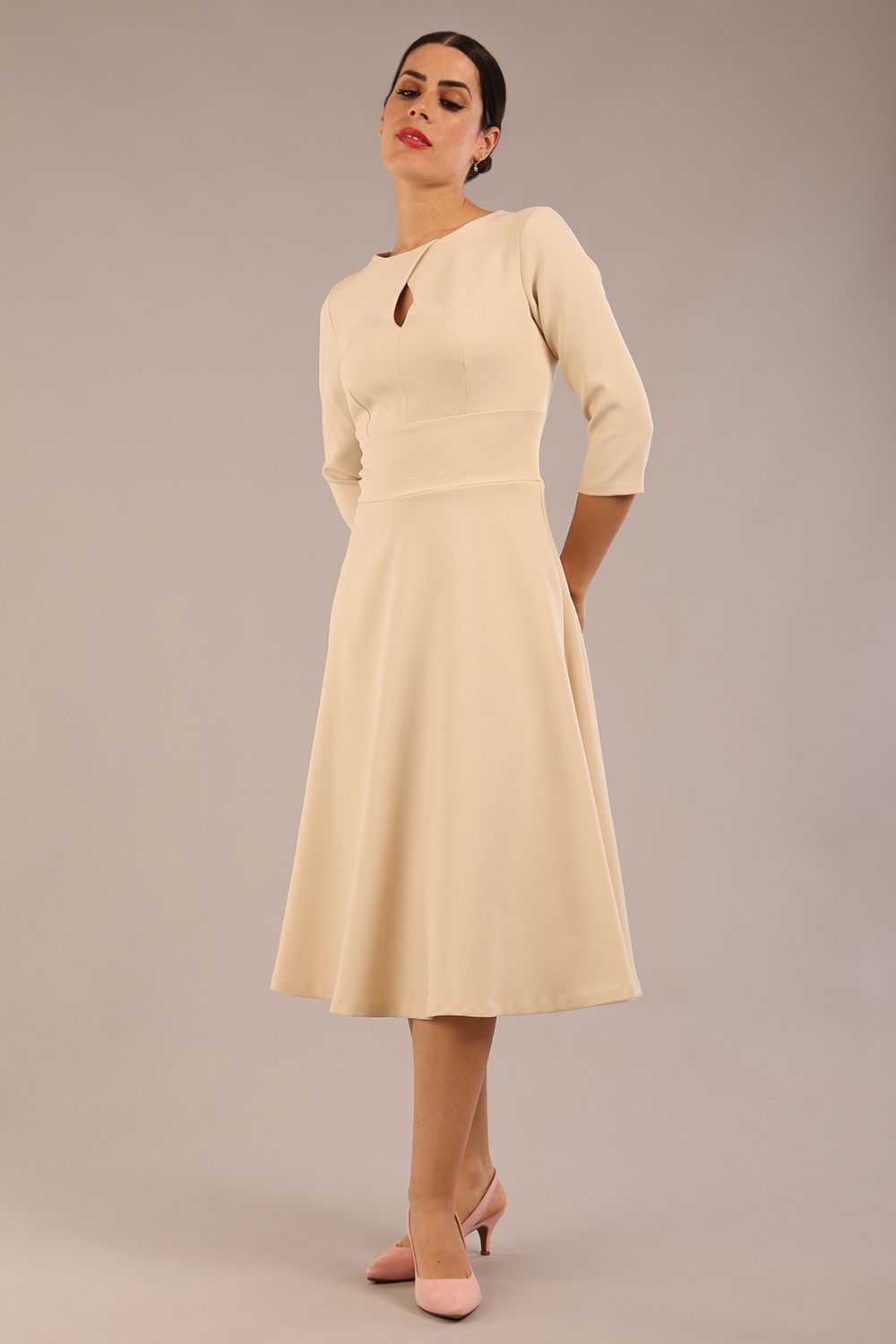 Brunette model is wearing diva catwalk casares swing dress with a keyhole neckline three quarter sleeve dress with pocket detail in Sandshell Beige front (Sandshell Beige)