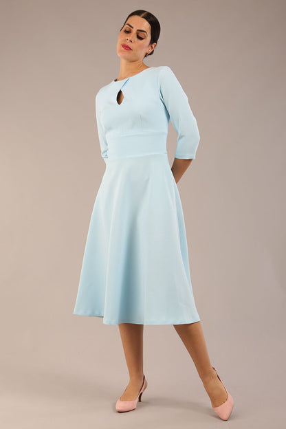 Brunette model is wearing diva catwalk casares swing dress with a keyhole neckline three quarter sleeve dress with pocket detail in sky blue front (Sky Blue)