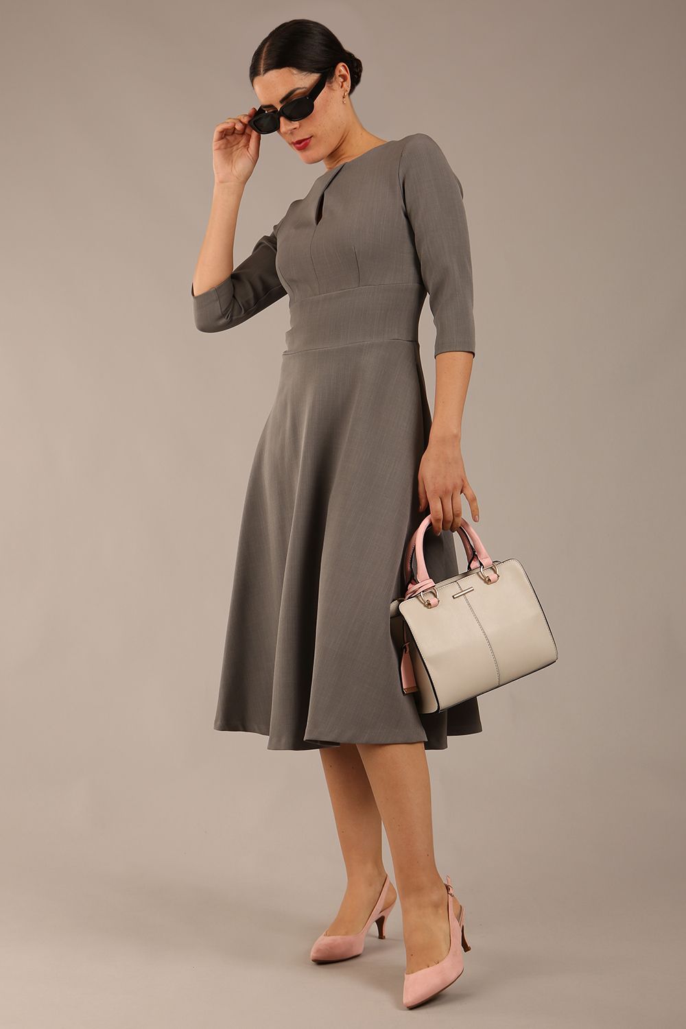 Brunette model is wearing diva catwalk casares swing dress with a keyhole neckline three quarter sleeve dress with pocket detail in Castlerock Grey  front (Castlerock Grey)
