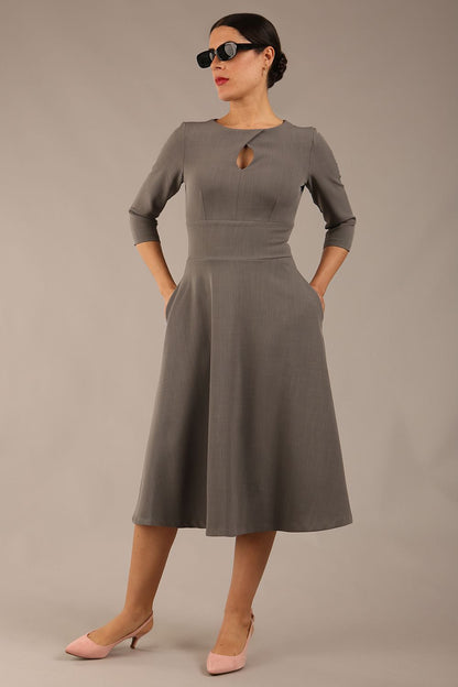 Brunette model is wearing diva catwalk casares swing dress with a keyhole neckline three quarter sleeve dress with pocket detail in Castlerock Grey  front (Castlerock Grey)