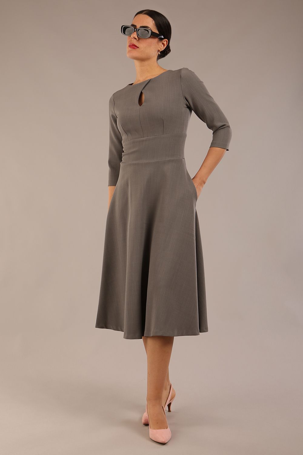 Brunette model is wearing diva catwalk casares swing dress with a keyhole neckline three quarter sleeve dress with pocket detail in Castlerock Grey  front (Castlerock Grey)