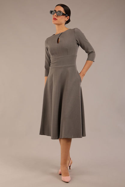 Brunette model is wearing diva catwalk casares swing dress with a keyhole neckline three quarter sleeve dress with pocket detail in Castlerock Grey  front (Castlerock Grey)