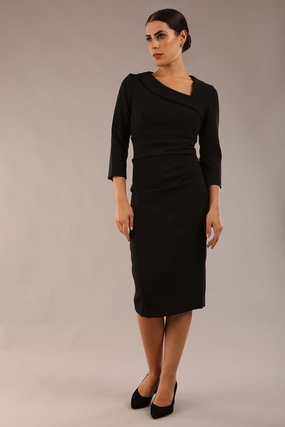 model is wearing a diva catwalk ed pencil three quarter sleeve dress with asymmetric neckline and pleating around tummy area front image black colour close up