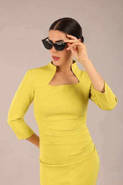 model is wearing diva catwalk plaza sheath dress with high neck Trapezium neckline cutout and three quarter sleeve pretty dress in citrus green front