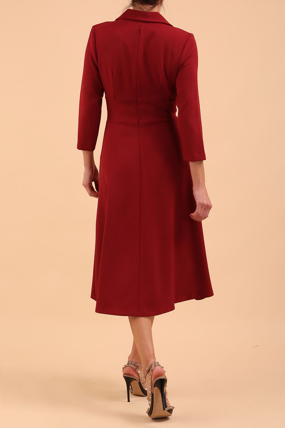 A blonde model is wearing a swing wine three quarter sleeve dress with oversized collar and pockets in the skirt  