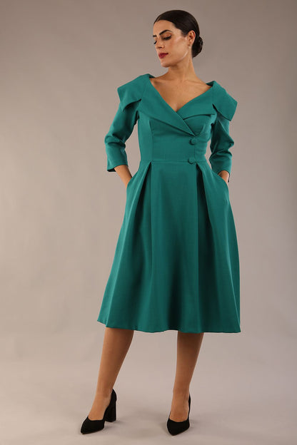 model is wearing diva catwalk gatsby swing dress with pocket detail and wide v-neck collar and buttons down the front panel in parasailing green front