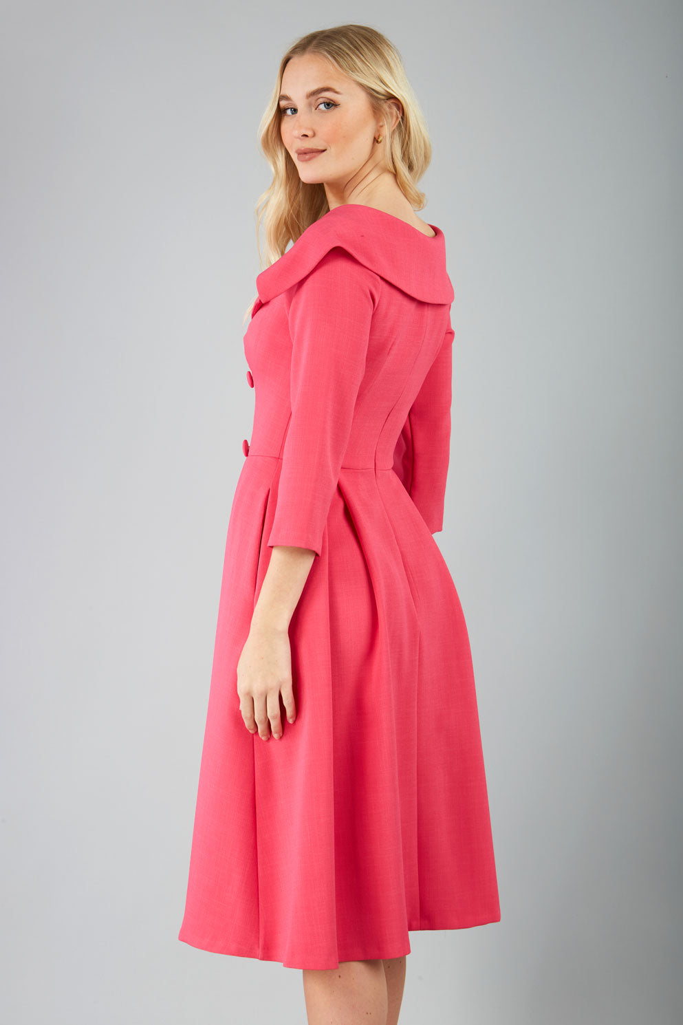 model is wearing diva catwalk gatsby swing dress with pocket detail and wide v-neck collar and buttons down the front panel in pink side back