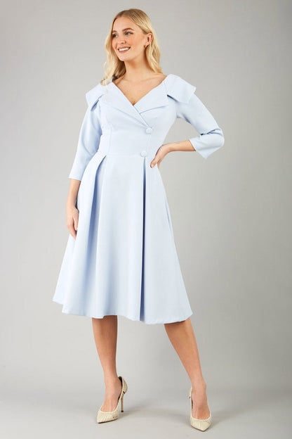 model is wearing diva catwalk gatsby swing dress with pocket detail and wide v-neck collar and buttons down the front panel in celestial blue front