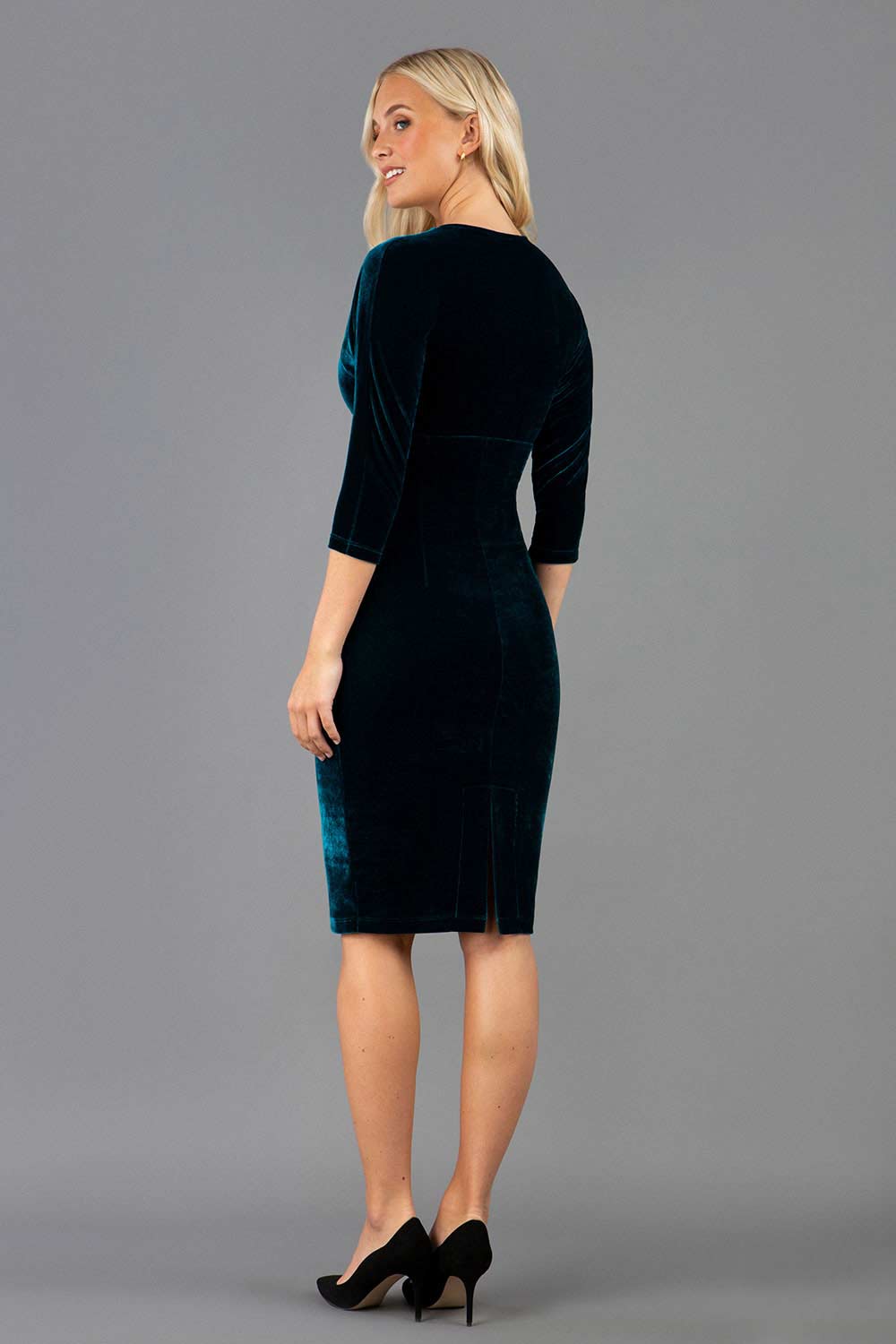 A blonde model is wearing a velvet pencil sweetheart neckline dress by diva catwalk in teal back image