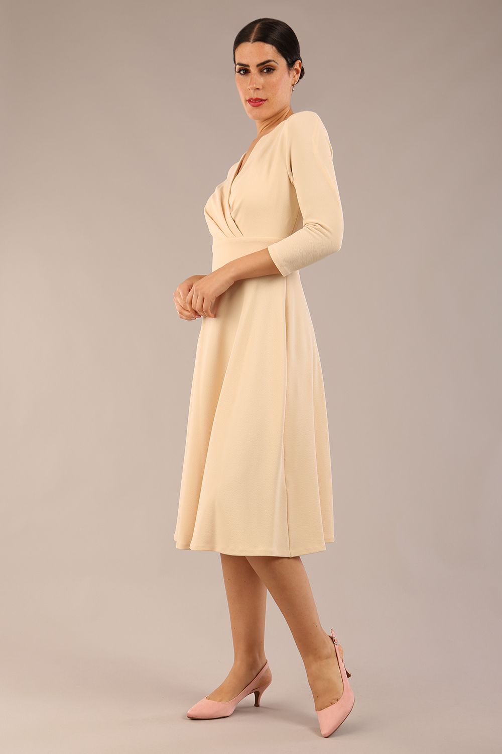 brunette model is wearing a diva catwalk january sleeved a-line swing v-neck dress in marvel fabric in beige colour front 