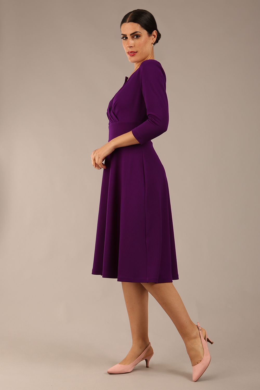 brunette model is wearing a diva catwalk january sleeved a-line swing v-neck dress in marvel fabric in deep purple colour front side