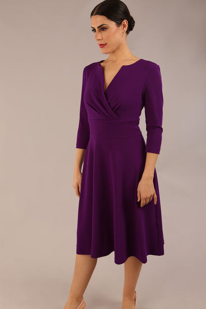 brunette model is wearing a diva catwalk january sleeved a-line swing v-neck dress in marvel fabric in deep purple colour front