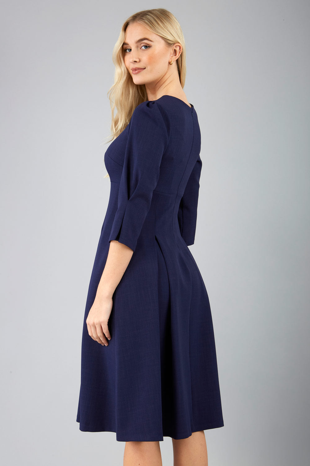 blonde model is wearing diva catwalk harpsden a-line skirt 3/4 sleeve swing dress with rounded neckline in navy blue front