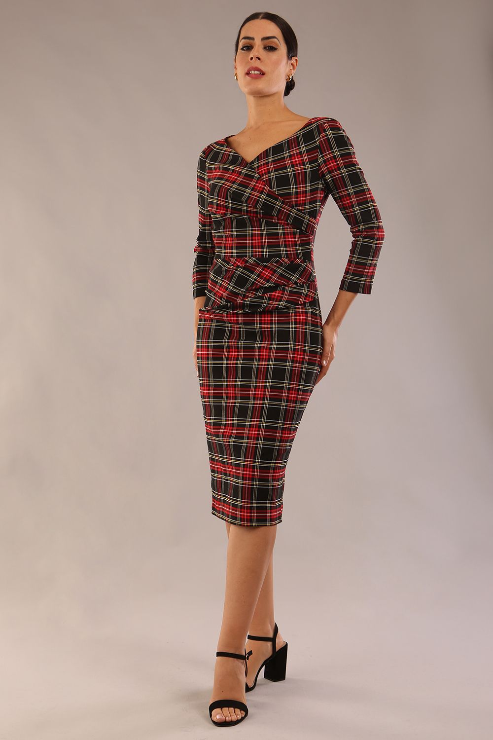 model is wearing a diva catwalk Horizon Tartan Stretch Pencil Dress with crossover v neckline and 3/4 sleeves and pleating details and knee length in luxury tartan stretch fabric in Royal Red Tartan