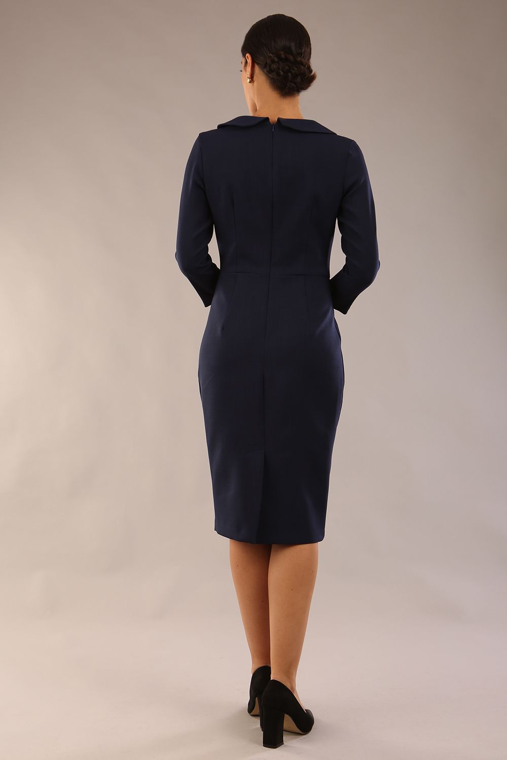 brunette model is wearing a diva catwalk  Helium 3/4 Sleeved Pencil Dress with 3/4 sleeve and knee length and bow detail on the neckline in navy blue colour front 