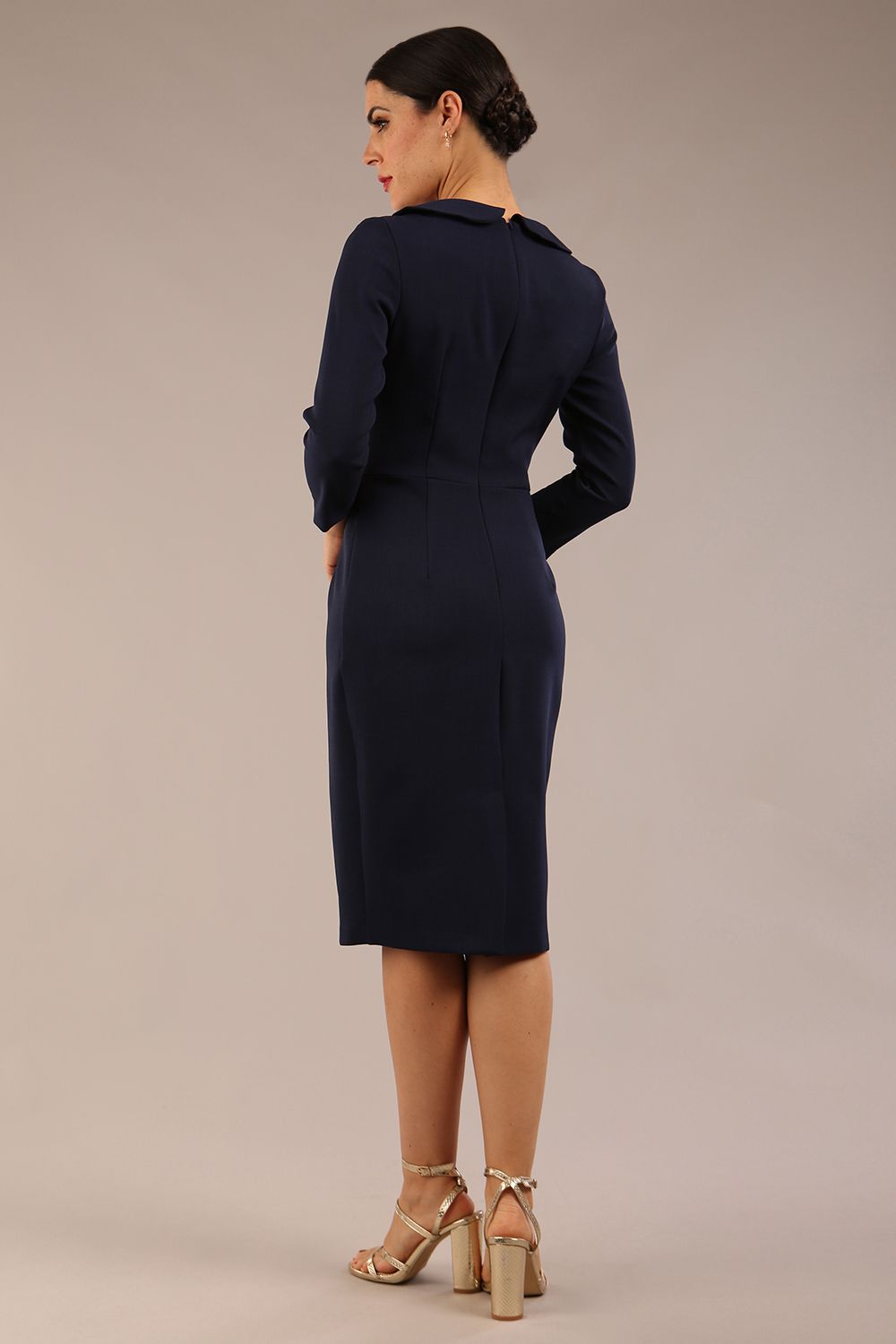 brunette model is wearing a diva catwalk  Helium 3/4 Sleeved Pencil Dress with 3/4 sleeve and knee length and bow detail on the neckline in navy blue colour front 